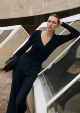 Mono largo de diseño combinado, con parte superior de tejido de punto acanalado con cuello en pico y cierre frontal de botones, y parte inferior de pantalón de corte recto. Cuenta con manga larga y bolsillos laterales.