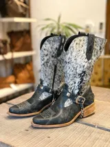 Botas de caña media de cuero negro con puntera cuadrada, detalle de cuero con estampado animal en la caña y correa con tachas alrededor del tobillo.