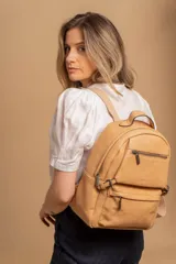 Mochila de cuero sintético color suela, con compartimento principal amplio, bolsillo frontal con cierre y correas ajustables.