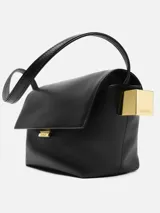 Bolso de mano negro de piel napa suave con asa de hombro, cierre de solapa plegable, charms de esfera y cubo bañados en oro, cierre magnético, bolsillo de parche en la parte trasera, bolsillo de parche interior y bolsillo con cremallera. Logotipo y herrajes bañados en oro. Interior totalmente forrado en algodón.