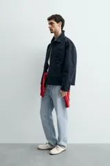 Sobrecamisa de corte relajado confeccionada en tejido de algodón con estructura canvas y efecto lavado. Presenta cuello solapa, cierre frontal con botones, mangas largas con puños abotonados y tres bolsillos frontales de plastrón.