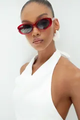 Top blanco de cuello halter con diseño drapeado en el frente y espalda descubierta.