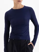 Remera de manga larga en color azul claro, confeccionada en tejido de poliamida y elastano con acabado semitransparente y cuello redondo.