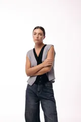 Chaleco tejido de punto con escote en V y cierre frontal con botones. Presenta una silueta recta y un diseño minimalista.