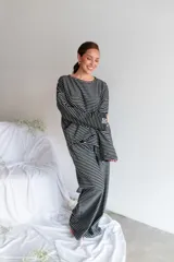 Conjunto de dos piezas de viscosa con estampado a rayas horizontales en color negro y blanco, compuesto por una remera de manga larga oversize y un pantalón largo de corte recto y holgado.