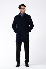 Abrigo clásico de paño azul marino, con cuello solapa, cierre frontal con botones y bolsillos laterales.