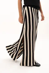 Pollera larga tejida a rayas verticales en color rojo y blanco, con pretina elástica y tajos laterales profundos que aportan movimiento.