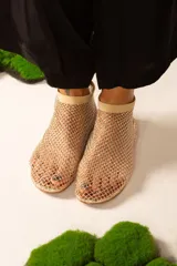 Botitas de red color beige con elástico en el tobillo.