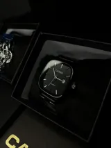 Reloj Casio con mecanismo de cuarzo, caja cuadrada de 36mm y malla de acero inoxidable, todo en color negro. Presenta esfera minimalista con indicadores de hora lineales y ventana de fecha.