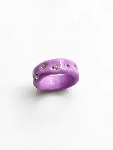 Anillo artesanal de arcilla polimérica en color lila, con diseño irregular y cristales incrustados en toda su superficie.