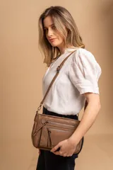 Bandolera de tamaño mediano confeccionada en símil cuero con detalles en nobuck. Cuenta con un compartimento principal con cierre, además de bolsillos frontales y traseros con cierre. Incluye correa ajustable y extraíble.