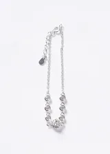 Pulsera de plata 925 con cadena de eslabones y dijes de zirconias blancas circulares, destacando un dije central en forma de corazón con incrustaciones de zirconias. Incluye cadena de extensión.