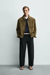 Sobrecamisa relaxed fit de piel con acabado en ante de color verde militar, con cuello solapa, manga larga con puño abotonado, bolsillos de vivo en la cadera y cierre frontal con botones.