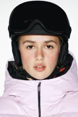 Campera puffer lila con capucha y forro negro, cierre frontal con cremallera, bolsillos laterales con cierre y puños negros ajustados.