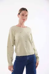 Sweater verde claro con bordado de flores pequeñas.