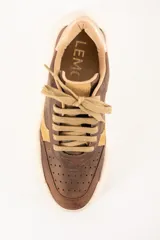 Zapatilla urbana de cuero color marrón con detalles en beige y dorado.