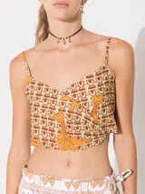 Top corto de lino color beige con estampado de palmeras en color naranja. Tiene breteles finos regulables y doble forro.