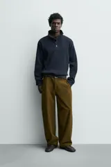 Sudadera de corte relajado confeccionada en tejido de algodón con textura waffle. Presenta cuello subido con cierre frontal de cuatro botones y mangas largas con puños y ruedo en rib.