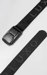 Cinturón de tela negra con hebilla metálica de liberación rápida en color negro mate. La cinta lleva el texto "LUX" y "LUXO" en relieve.