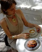 Collar artesanal con dije central de metal con textura orgánica irregular que evoca una ostra. El dije está montado sobre un cordón de algodón natural, permitiendo un uso versátil y regulable.