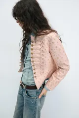 Blazer entallada de cuello alto y manga larga, en color rosado con estampado de flores amarillas. Cuenta con detalle de pasamanería en el delantero y cierre frontal con botones metálicos dorados.