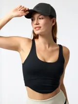 Top deportivo negro de corte crop, con costuras visibles de inspiración corsetera en el pecho, tirantes anchos y espalda rebajada.