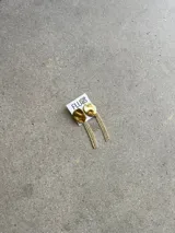 Caravanas colgantes de diseño irregular con base circular texturizada en tono dorado y flecos largos de strass brillantes.