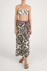 Falda larga fluida de diseño envolvente con estampado paisley en tonos bordó, negro y blanco, con cintura alta decorada con cenefa geométrica y lazo lateral.