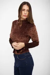 Top de manga larga con cuello alto, confeccionado en tejido aterciopelado con estampado animal print de leopardo en tonos marrones.
