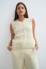 Chaleco de lana color crudo, tejido con escote en V y diseño con diferentes puntos combinados en el frente.