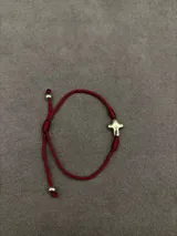 Set de tres pulseras ajustables de cordón con detalles religiosos. Incluye una pulsera roja con cruces, una pulsera marrón trenzada con cruz y medallas, y una pulsera verde con medalla colgante.