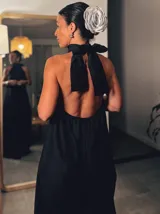 Mono largo negro con cuello halter y corte palazzo. Incluye un collar plateado con dije de hueso.