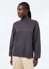 Buzo tejido violeta con cuello alto, mangas largas y puños y ruedo acanalados.
