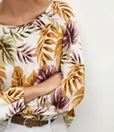 Blusa de viscosa con estampado de follajes en tonos tierra, escote bote y mangas largas abullonadas con puños elásticos.