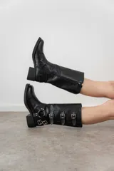 Bota de caña media color gris con hebillas metálicas decorativas y suela track.