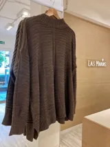 Sweater tejido color marrón con cuello alto y mangas largas. Diseño holgado con textura acanalada.