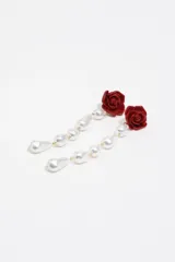 Pendientes largos con diseño de rosa roja en la parte superior y una serie de perlas barrocas colgantes unidas por eslabones dorados.