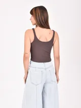 Musculosa de tejido acanalado color beige, con escote redondo y estampado frontal con la frase 'LESS IS MORE' en color negro.