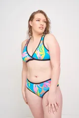 Corpiño de bikini triangular con estampado de hojas en tonos azules y contorno en color verde agua.