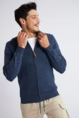 Campera tejida de punto en color verde militar, con cierre frontal completo, cuello elevado y ajuste regular. Presenta un diseño texturizado con logo bordado en el pecho y puños acanalados.