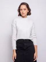 Polera color gris claro de tejido tramado, cuello alto y manga larga.