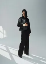 Pantalon de vestir negro de corte recto y tiro medio, con trabillas en la cintura, cierre oculto y lazo ajustable. Cuenta con bolsillos laterales y forro interior.