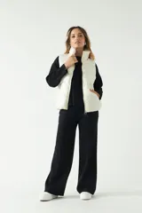 Chaleco puffer color crema con textura acolchada y bolsillos con cierre.