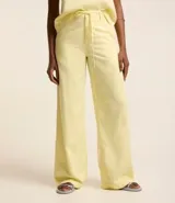 Pantalón wide leg color amarillo pálido, confeccionado en sarga leve, con cintura alta y cordón de ajuste.