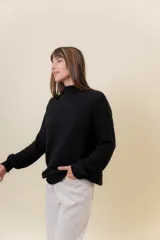 Polera de tejido de punto con textura marcada, cuello alto y diseño oversize con hombros caídos y terminaciones acanaladas.