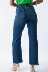 Pantalón de jean azul de corte recto con terminación desflecada y cadena dorada decorativa.