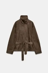 Chaqueta de efecto ante color marrón, con cuello subido, manga larga y bolsillos frontales. Cuenta con cierre cruzado con botones y cinturón ajustable del mismo tejido.