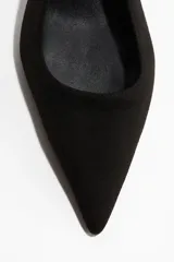 Zapatos negros destalonados con punta fina y taco bajo tipo kitten heel. Poseen una tira elástica en el talón para ajuste y forro de satén.