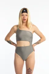 Traje de baño enterizo color gris, de un solo hombro, con abertura en la zona abdominal.