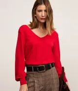 Blusa roja de manga larga confeccionada en punto de viscosa, con escote en V pronunciado en la parte delantera y hombreras.